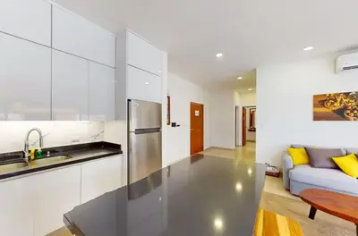 a kitchen with a stainless steel refrigerator next to a couch at Casa Corales Dreams 1 in Playa Flamingo