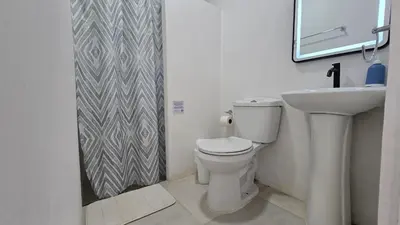 a bathroom with a toilet and a sink and a mirror at Mango Coliving Rooms for Digital Nomads in Uvita