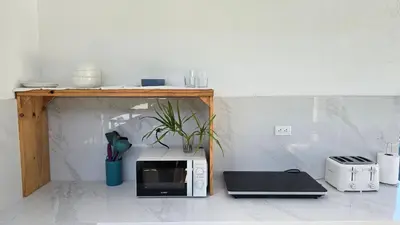 a microwave sitting on a counter next to a table at Mango Coliving Rooms for Digital Nomads in Uvita