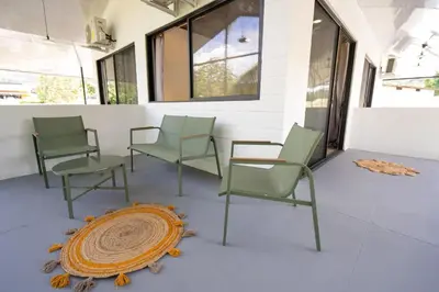 a group of chairs and a rug on a porch at Mango Coliving Rooms for Digital Nomads in Uvita