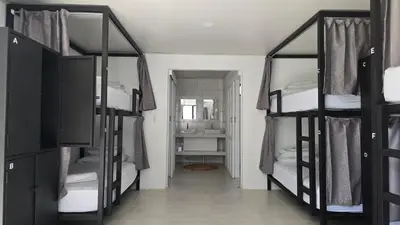 a room with three bunk beds and a hallway at Mango Coliving Rooms for Digital Nomads in Uvita