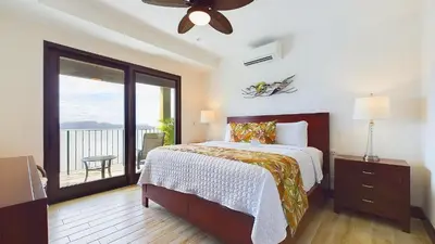 a bedroom with a large bed and a balcony at 360 Splendor 208F- Ocean View Condo, Breakfast in Playa Flamingo