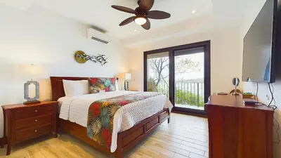 a bedroom with a bed and a ceiling fan at 360 Splendor 208F- Ocean View Condo, Breakfast in Playa Flamingo