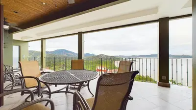 a balcony with a table and chairs and a view of the mountains at 360 Splendor 208F- Ocean View Condo, Breakfast in Playa Flamingo