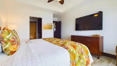 a bedroom with a bed and a flat screen tv at 360 Splendor 208A- Ocean View Condo, Breakfast in Playa Flamingo