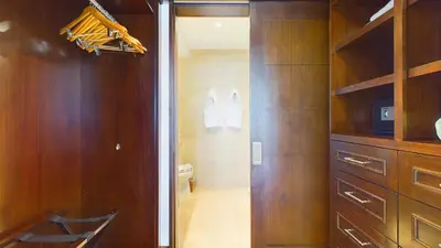 a bathroom with a toilet and a wooden closet at 360 Splendor 208A- Ocean View Condo, Breakfast in Playa Flamingo