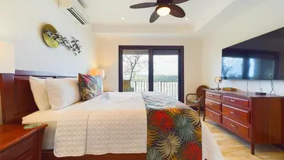 a bedroom with a bed and a dresser and a window at 360 Splendor 208A- Ocean View Condo, Breakfast in Playa Flamingo