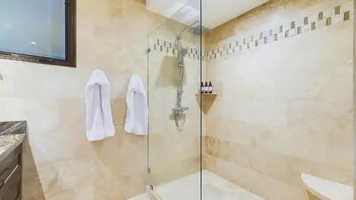 a bathroom with a shower with a glass door at 360 Splendor 208A- Ocean View Condo, Breakfast in Playa Flamingo
