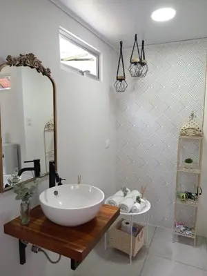 a bathroom with a large white sink and a mirror at Casita Bohemia natural paradise in Peje Viejo