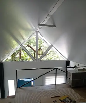 a room with a large window in a loft at Casita Bohemia natural paradise in Peje Viejo