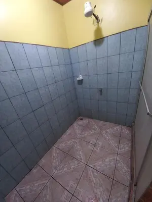 a bathroom with a tiled floor and a shower at Cabinas Ruma in Muelle