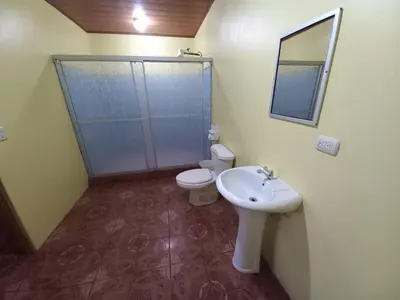 a bathroom with a toilet and a sink and a mirror at Cabinas Ruma in Muelle