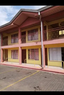 a pink and yellow building with a balcony at Cabinas Ruma in Muelle