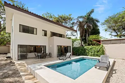 a home with a swimming pool and a house at Casa Oasis Beach Villa with Pool, Playa Grande in Santa Cruz