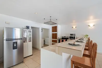 a kitchen and dining room with a stainless steel refrigerator at Casa Oasis Beach Villa with Pool, Playa Grande in Santa Cruz