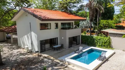 a villa with a swimming pool and a house at Casa Oasis Beach Villa with Pool, Playa Grande in Santa Cruz
