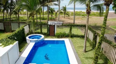 a swimming pool with a toilet next to a beach at Millys House 6p max Jacó CR in Jacó