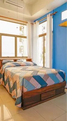 a bedroom with a bed with a blue wall at Millys House 6p max Jacó CR in Jacó