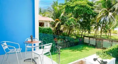 a balcony with a table and chairs and a garden at Millys house 12p max Jacó CR in Jacó