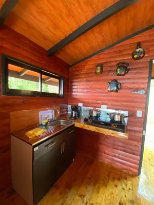 a kitchen with wooden walls and a sink and a stove at Cabaña Con Hermosa vista y ambiente de campo in Miravalles