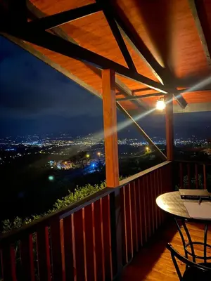 a balcony with a view of a city at night at Cabaña Con Hermosa vista y ambiente de campo in Miravalles