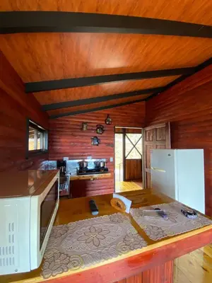 a kitchen with wooden walls and a white microwave at Cabaña Con Hermosa vista y ambiente de campo in Miravalles