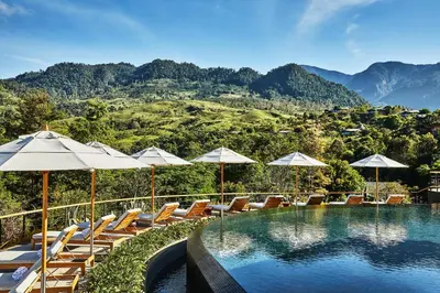 a swimming pool with lounge chairs and umbrellas at Hacienda AltaGracia, Auberge Collection in Santa Elena
