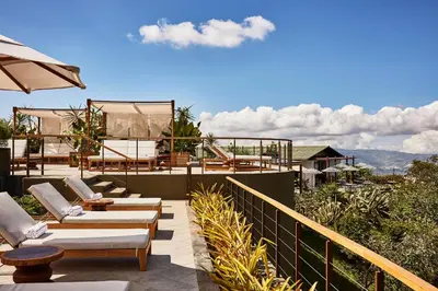a patio with chairs and an umbrella on a balcony at Hacienda AltaGracia, Auberge Collection in Santa Elena