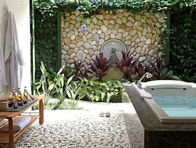 a bathroom with a bath tub and a stone wall at Hacienda AltaGracia, Auberge Collection in Santa Elena