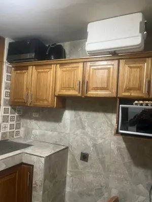 a kitchen with wooden cabinets and a counter top at Pinky s Place Alajuela City Airport Costa Rica in Alajuela City