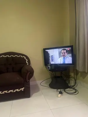 a television sitting in a living room with a couch at Pinky s Place Alajuela City Airport Costa Rica in Alajuela City