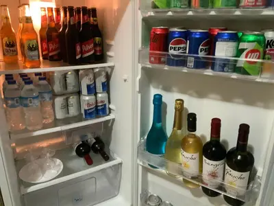 an open refrigerator filled with lots of bottles of alcohol at Pinky s Place Alajuela City Airport Costa Rica in Alajuela City