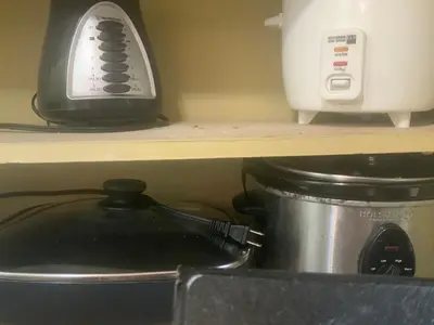 a slow cooker and a toaster on a shelf at Pinky s Place Alajuela City Airport Costa Rica in Alajuela City