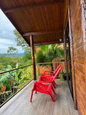 two red benches on the porch of a house at Villa Lomas Sarapiquí in Colonia Carvajal