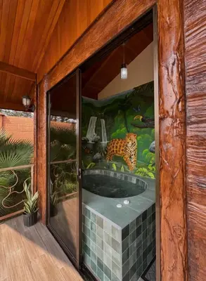 a bathroom with a jacuzzi tub with a tiger mural at Villa Lomas Sarapiquí in Colonia Carvajal
