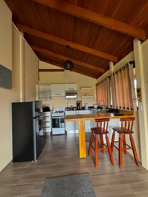 a kitchen with a large wooden table and chairs at Villa Lomas Sarapiquí in Colonia Carvajal