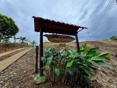 a sign on the side of a dirt road at Villa Lomas Sarapiquí in Colonia Carvajal
