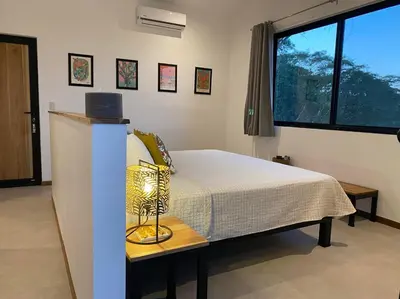 a bedroom with a bed with a lamp on a table at Finca Quietud in Tarcoles