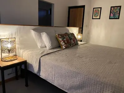 a bedroom with a white bed with a side table at Finca Quietud in Tarcoles
