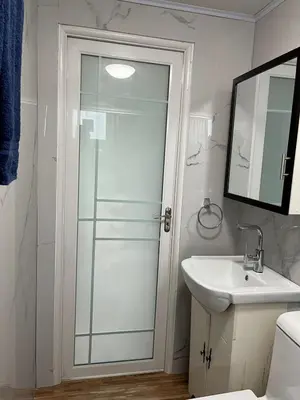 a bathroom with a glass shower and a sink at Beautiful tiny house with AC WIFI in Santa Cruz