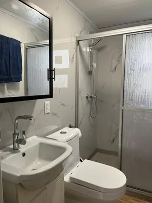 a bathroom with a toilet and a sink and a shower at Beautiful tiny house with AC WIFI in Santa Cruz