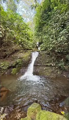 a small waterfall on the side of a river at Sunset Farms and Waterfalls! in Tilarán