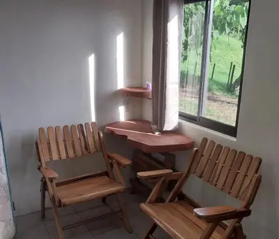 two chairs and a table in a room with a window at Sunset Farms and Waterfalls! in Tilarán