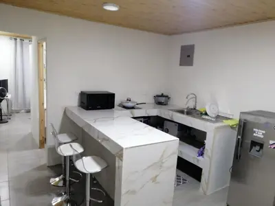 a kitchen with a sink and a counter with stools at Apartamento JOKO in Villarreal