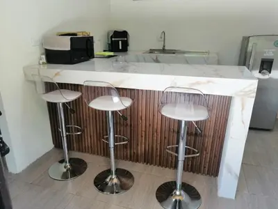 a kitchen with a counter with three bar stools at Apartamento JOKO in Villarreal