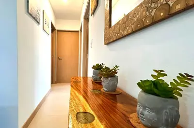 a hallway with three potted plants on a wooden table at Modern Paradise Relax & Explore at Viva Jaco in Jacó