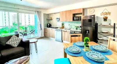 a kitchen and living room with a table with plates on it at Modern Paradise Relax & Explore at Viva Jaco in Jacó