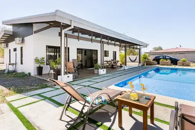 a villa with a swimming pool and a house at Quinta Bella in Bagaces