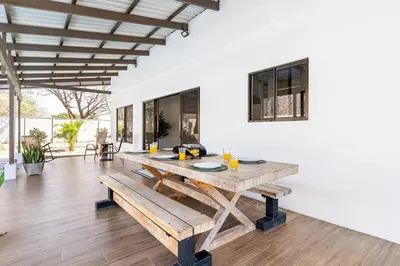 a dining room with a wooden table and benches at Quinta Bella in Bagaces