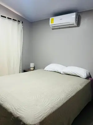 a bedroom with a bed with a air conditioner on the wall at Epic Arenal View House in Fortuna